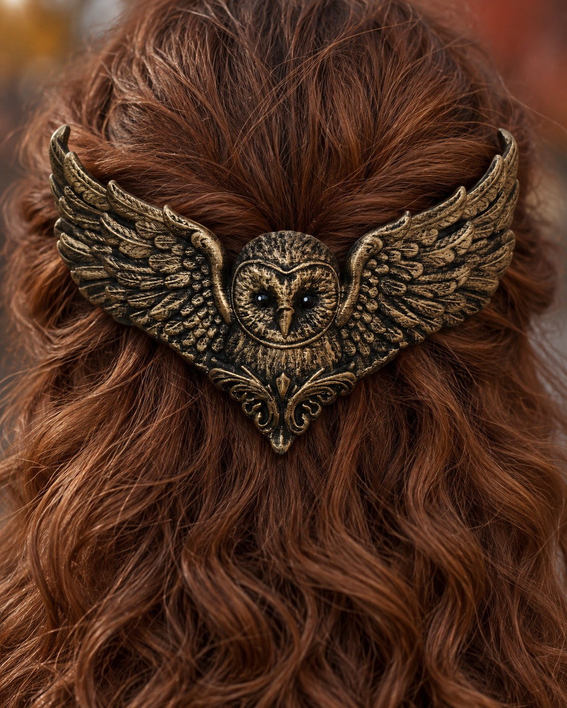 The Golden owl crown worn in curly auburn hair, close-up